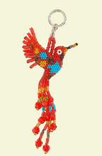 Colorful beaded bird keychain on a beige background