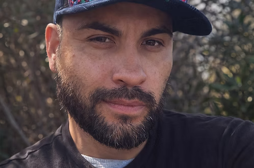 Man wearing a cap with a blurred natural background