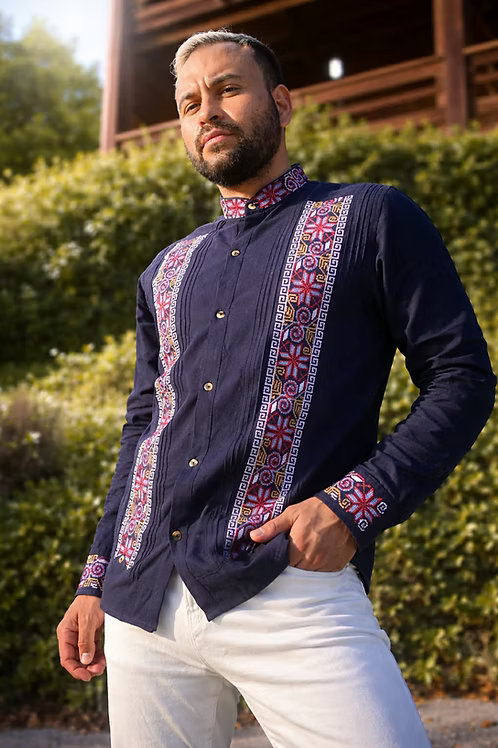 Man wearing a dark blue shirt with colorful patterned accents outdoors
